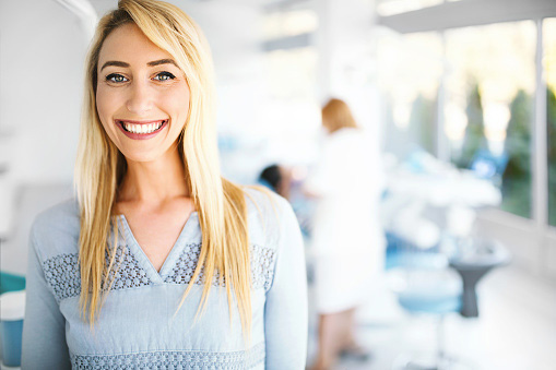 Young female patient smiling and looking at camera after leaving a positive review for Singing River Dentistry in Muscle Shoals, AL