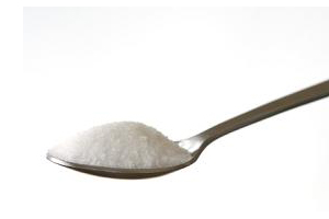 silver spoon holding a scoop of white sugar